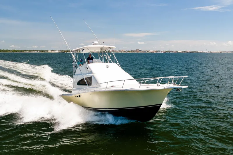 Slide: The Image of 1994 Luhrs 38 Convertible yacht cruising on open water under clear skies. - 18