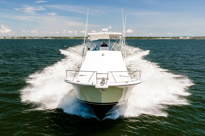 Slide: The Image of 1994 Luhrs 38 Convertible yacht cruising on open water, creating a dynamic wake. - 19