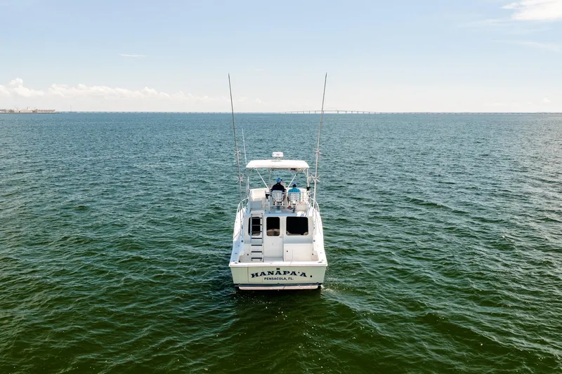 Slide: The Image of 1994 Luhrs 38 Convertible boat on open water, rear view, clear sky. - 20