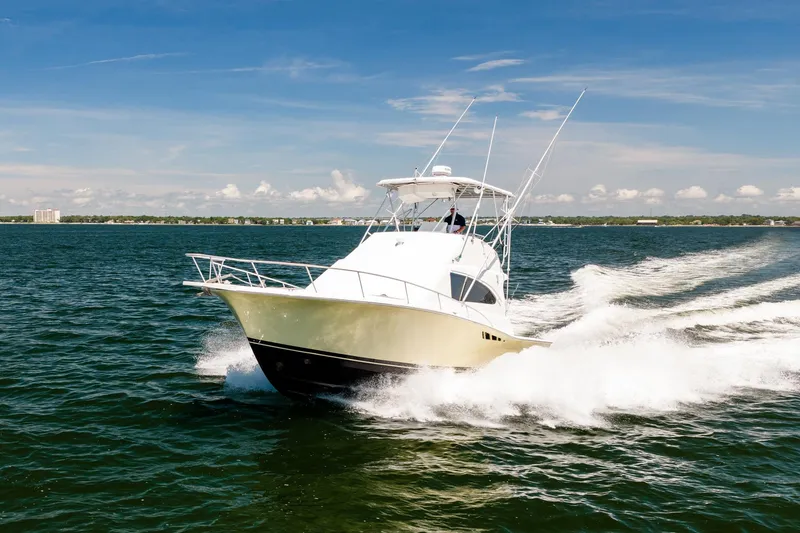 Slide: The Image of 1994 Luhrs 38 Convertible yacht cruising on open water under clear skies. - 25