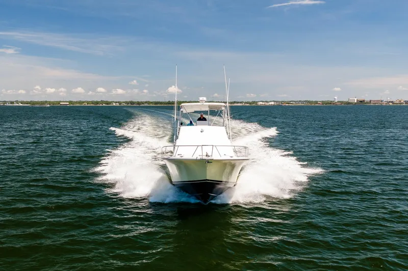 Slide: The Image of 1994 Luhrs 38 Convertible yacht cruising on open water under a clear blue sky. - 26