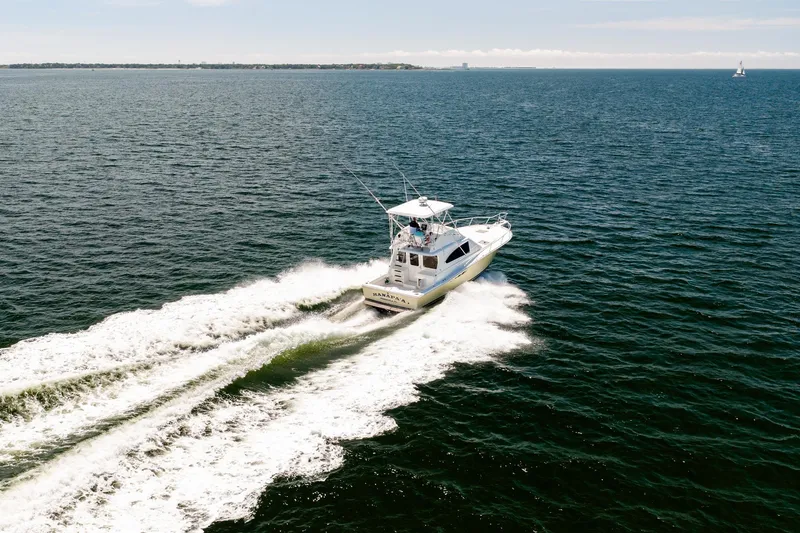 Slide: The Image of 1994 Luhrs 38 Convertible yacht cruising on open water. - 28