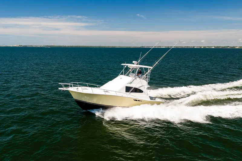 Slide: The Image of 1994 Luhrs 38 Convertible yacht cruising on open water under clear skies. - 33