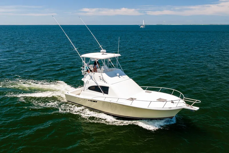 Slide: The Image of 1994 Luhrs 38 Convertible yacht cruising on open sea under clear skies. - 37