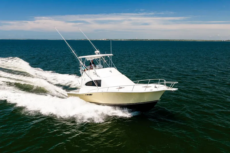 Slide: The Image of 1994 Luhrs 38 Convertible yacht cruising on open water under clear skies. - 39