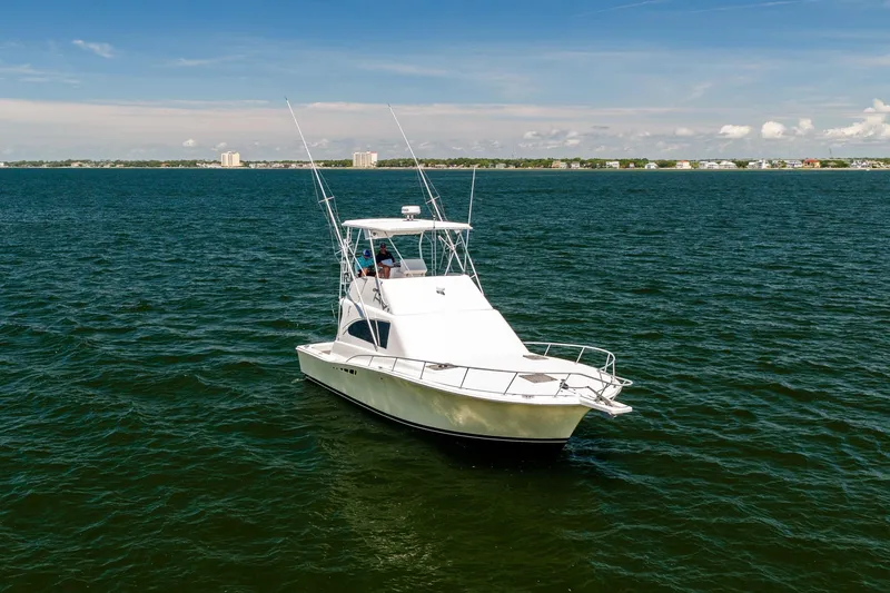 Slide: The Image of 1994 Luhrs 38 Convertible yacht cruising on open water under clear skies. - 4