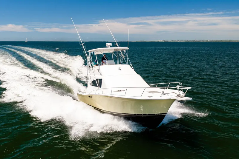 Slide: The Image of 1994 Luhrs 38 Convertible yacht cruising on open water under clear skies. - 42