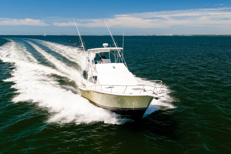Slide: The Image of 1994 Luhrs 38 Convertible yacht cruising on open water under clear skies. - 43