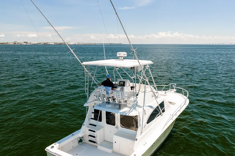 Slide: The Image of 1994 Luhrs 38 Convertible yacht cruising on open water under clear skies. - 49