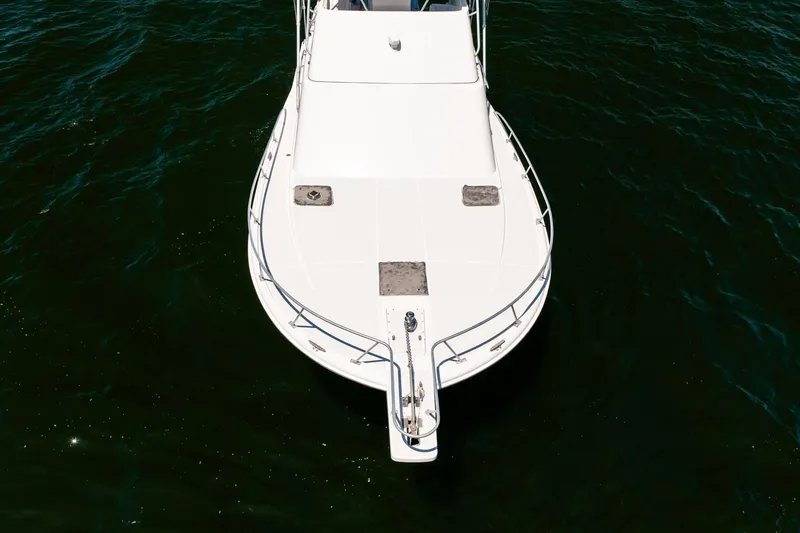 Slide: The Image of 1994 Luhrs 38 Convertible boat on water, top view of bow. - 57