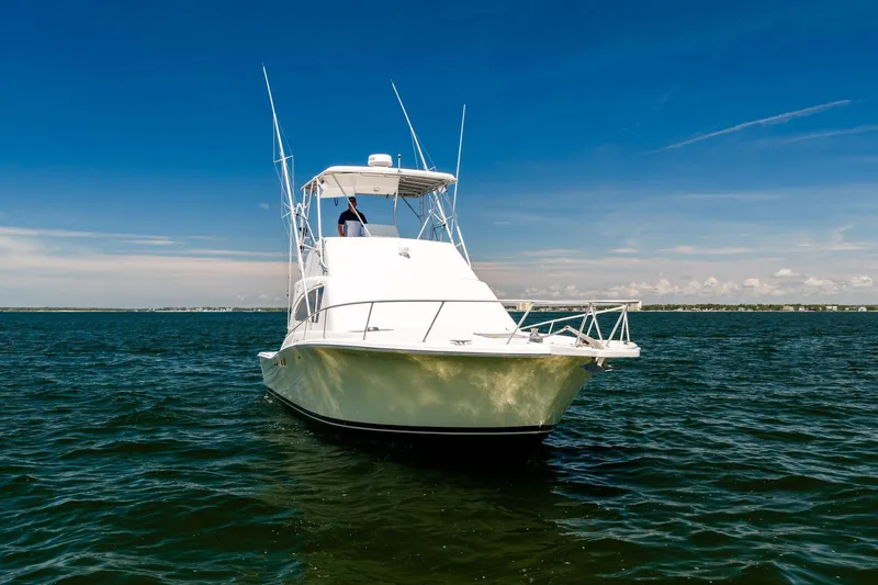 Slide: The Image of 1994 Luhrs 38 Convertible boat on open water under clear blue sky. - 58