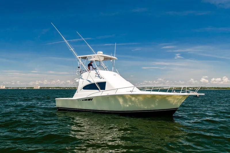 Slide: The Image of 1994 Luhrs 38 Convertible yacht cruising on open water under clear blue sky. - 59