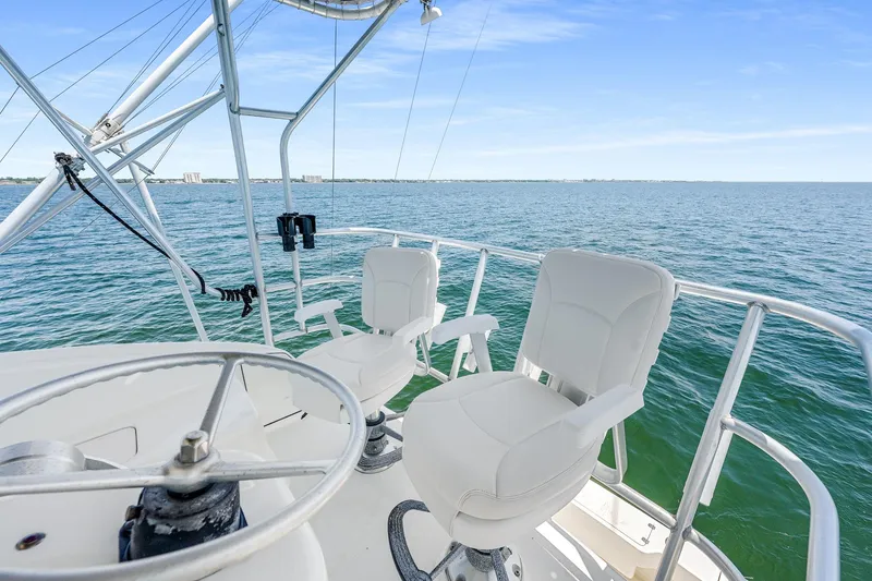 Slide: The Image of 1994 Luhrs 38 Convertible yacht helm with ocean view and white captain chairs. - 6