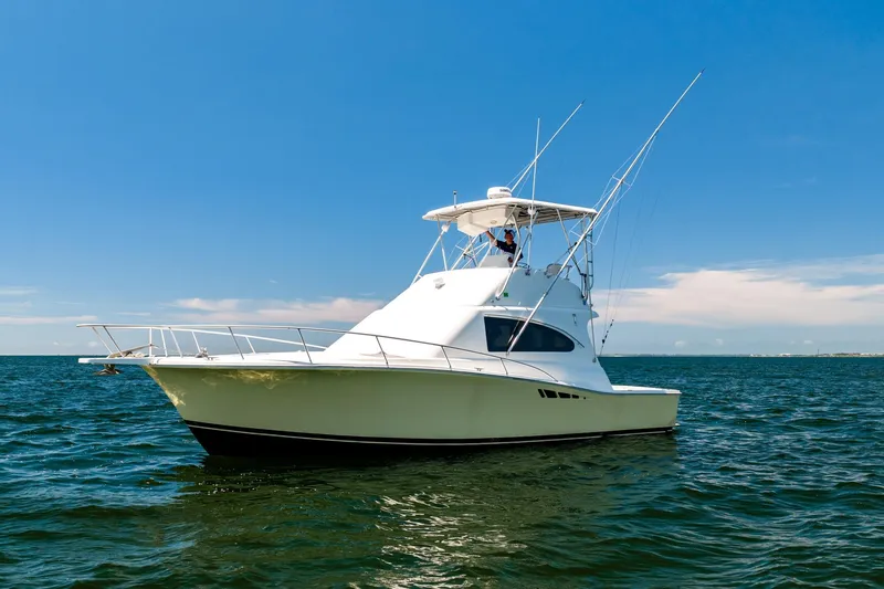 Slide: The Image of 1994 Luhrs 38 Convertible yacht on open water under clear blue sky. - 60