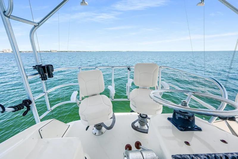 Slide: The Image of 1994 Luhrs 38 Convertible boat helm with ocean view and white captain chairs. - 66