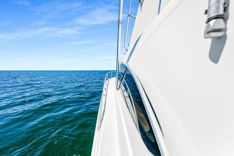 Slide: The Image of 1994 Luhrs 38 Convertible yacht cruising on open sea under clear blue sky. - 67