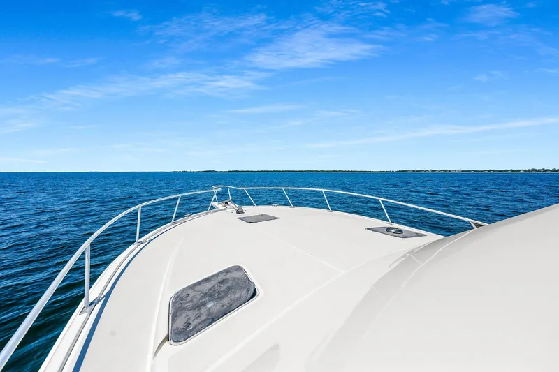 Slide: The Image of 1994 Luhrs 38 Convertible boat cruising on open water under clear blue sky. - 68