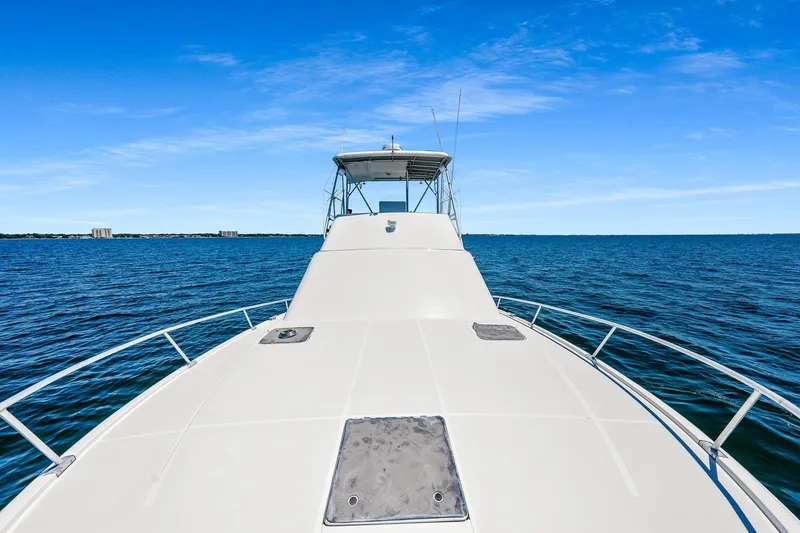 Slide: The Image of 1994 Luhrs 38 Convertible yacht cruising on open water under clear blue skies. - 70