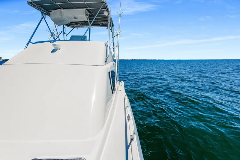 Slide: The Image of 1994 Luhrs 38 Convertible yacht cruising on open blue sea under clear sky. - 72