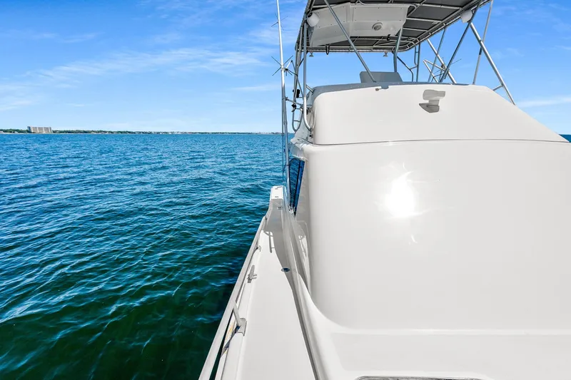 Slide: The Image of 1994 Luhrs 38 Convertible yacht cruising on open blue water under clear skies. - 73