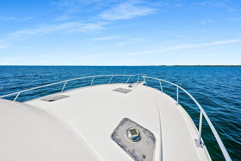 Slide: The Image of 1994 Luhrs 38 Convertible boat cruising on open blue water under clear sky. - 74