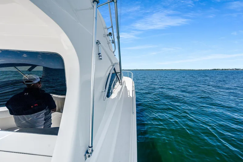 Slide: The Image of 1994 Luhrs 38 Convertible yacht cruising on open water under clear blue skies. - 75