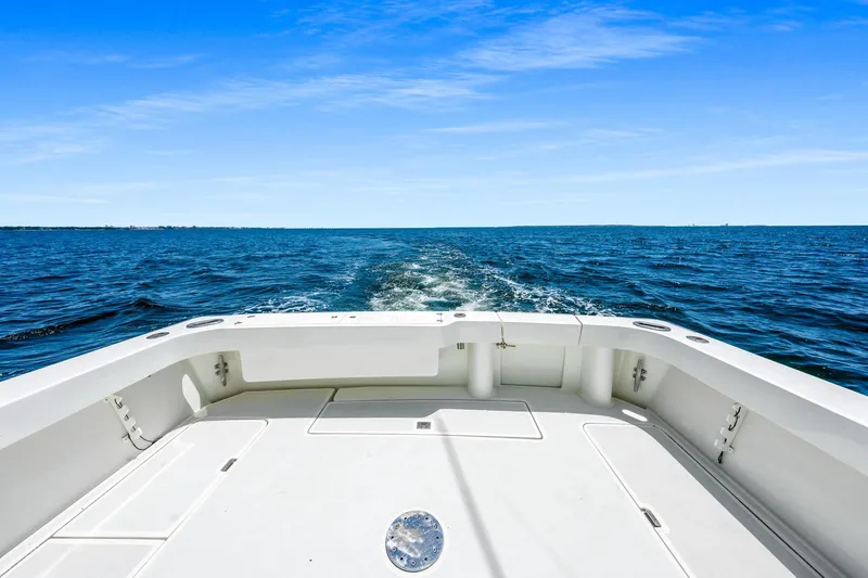 Slide: The Image of 1994 Luhrs 38 Convertible boat cruising on open ocean under clear blue sky. - 79