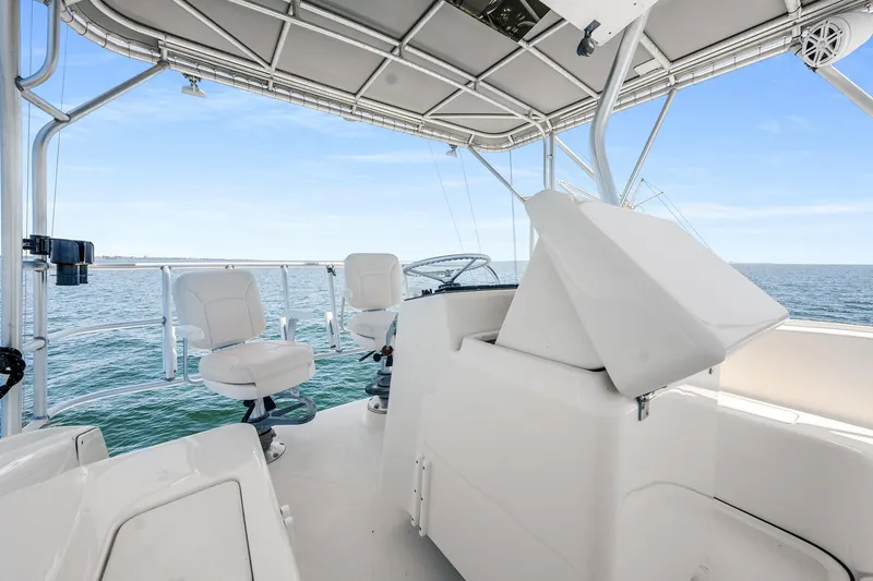 Slide: The Image of 1994 Luhrs 38 Convertible boat interior with helm and seating, overlooking the ocean. - 8