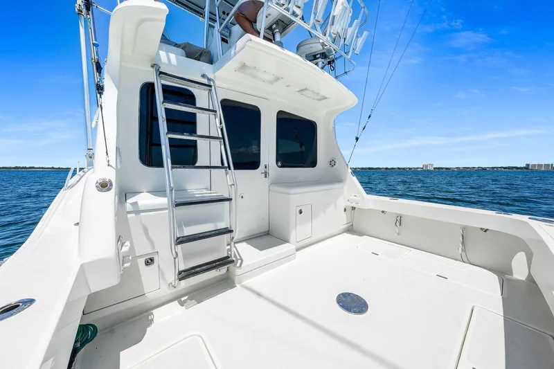 Slide: The Image of 1994 Luhrs 38 Convertible yacht deck with ladder, overlooking calm blue waters. - 80