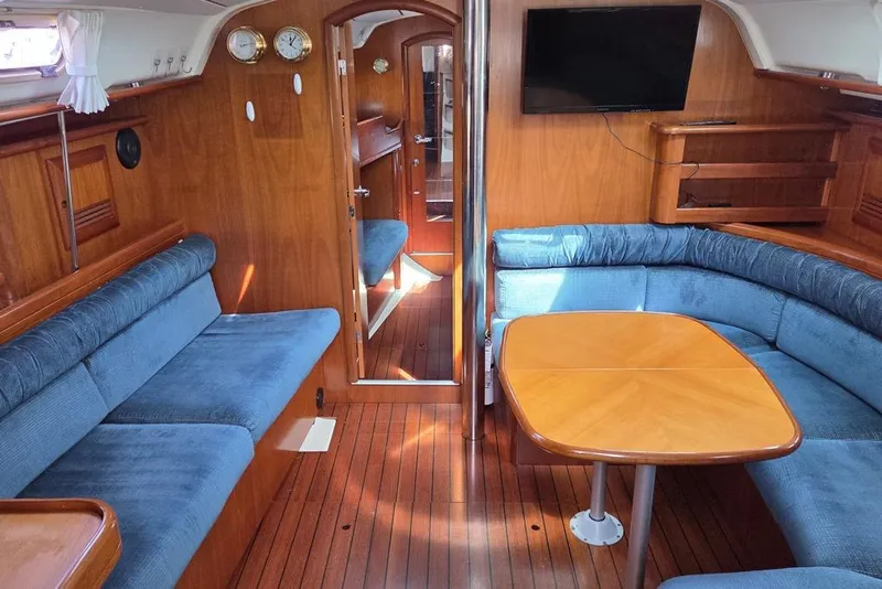 Slide: The Image of Interior of 2000 Beneteau Oceanis 411 yacht with blue upholstery and cherry wood finish - 1