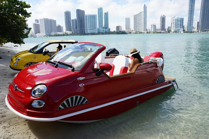 Slide: The Image of Red Fiat 500 Classic boat on water, city skyline in background, 2025 model. - 11