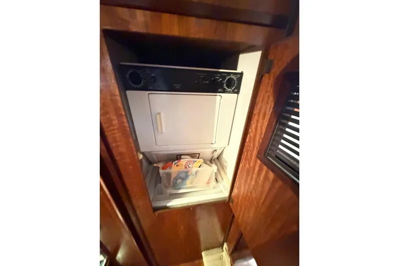 Slide: The Image of Laundry area inside a 1978 Hatteras 53 Motor Yacht with wooden cabinetry. - 12