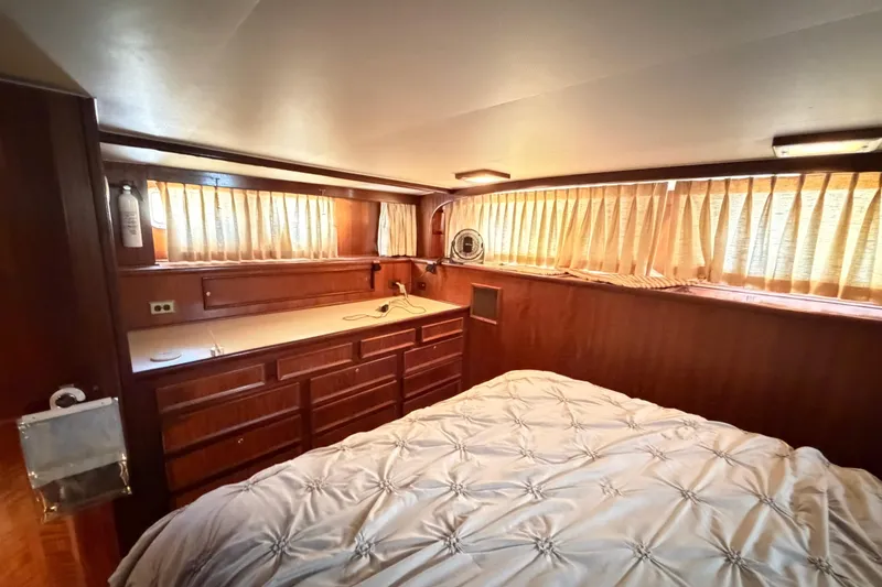 Slide: The Image of 1978 Hatteras 53 Motor Yacht bedroom with wood paneling and soft lighting. - 23