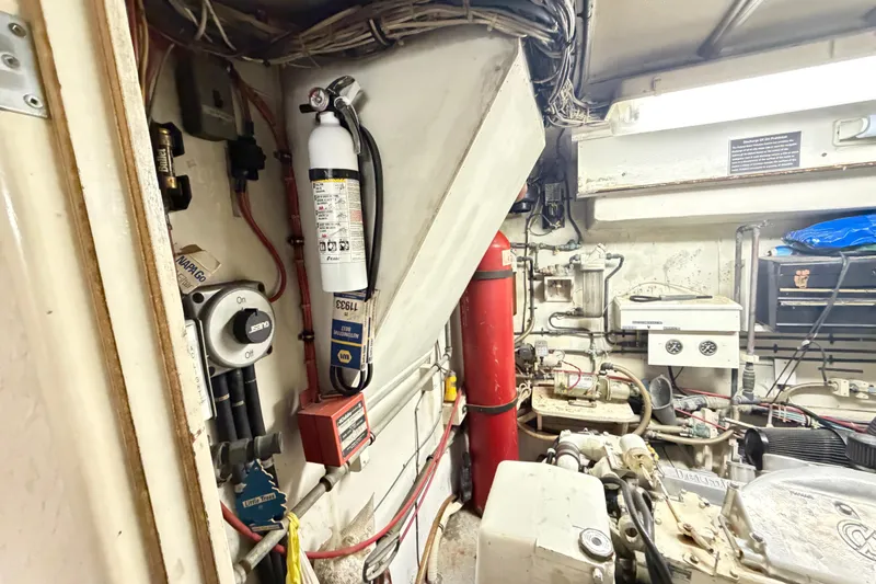 Slide: The Image of Engine room of a 1978 Hatteras 53 Motor Yacht with fire extinguisher and wiring. - 25