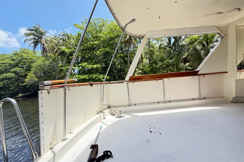 Slide: The Image of 1978 Hatteras 53 Motor Yacht deck with lush tropical backdrop. - 29
