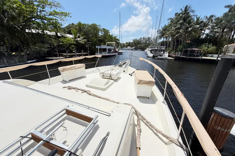 Slide: The Image of 1978 Hatteras 53 Motor Yacht docked on a sunny day, surrounded by lush greenery. - 3