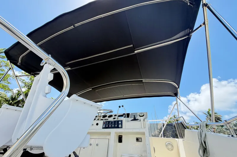 Slide: The Image of 1978 Hatteras 53 Motor Yacht helm with black canopy under blue sky. - 34