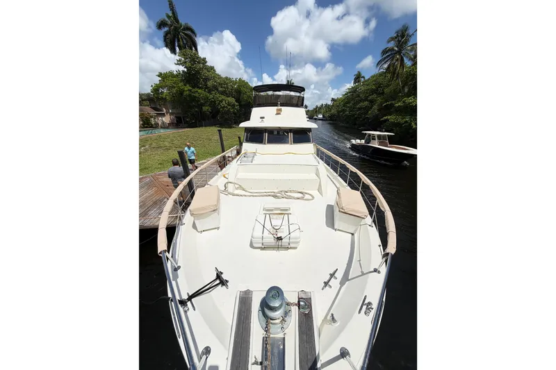 Slide: The Image of 1978 Hatteras 53 Motor Yacht docked on a sunny day, surrounded by lush greenery. - 4