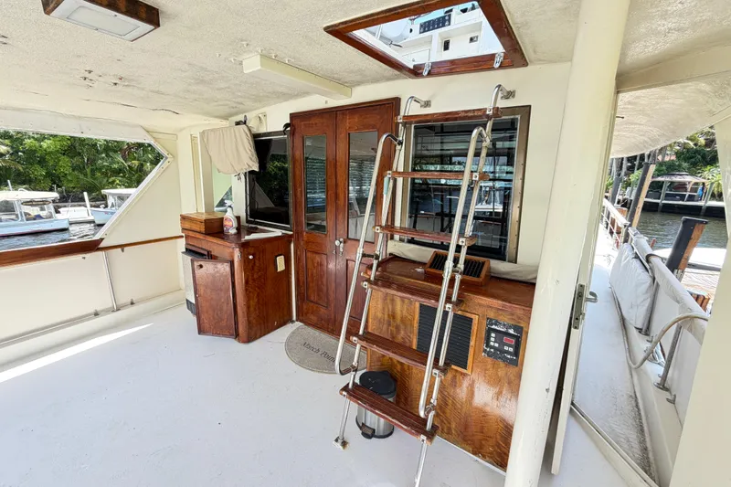 Slide: The Image of 1978 Hatteras 53 Motor Yacht interior with wooden cabinetry and ladder, docked by the water. - 44