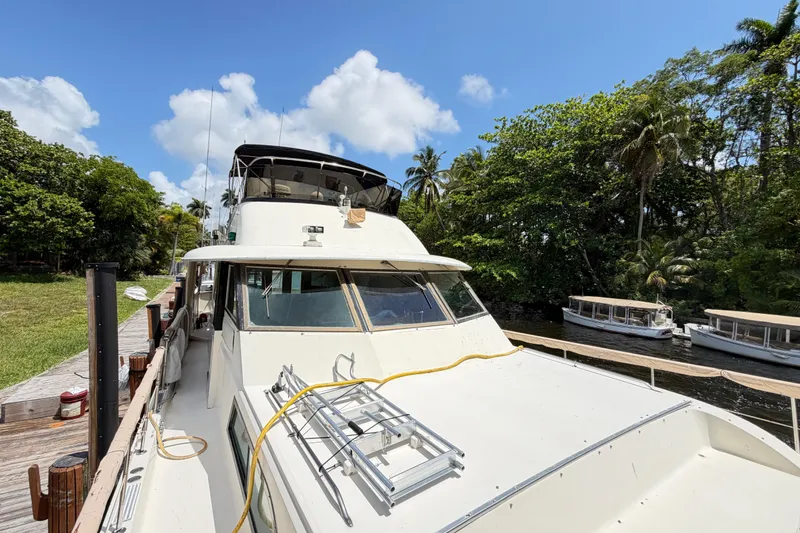 Slide: The Image of 1978 Hatteras 53 Motor Yacht docked near lush greenery and calm waterway. - 5