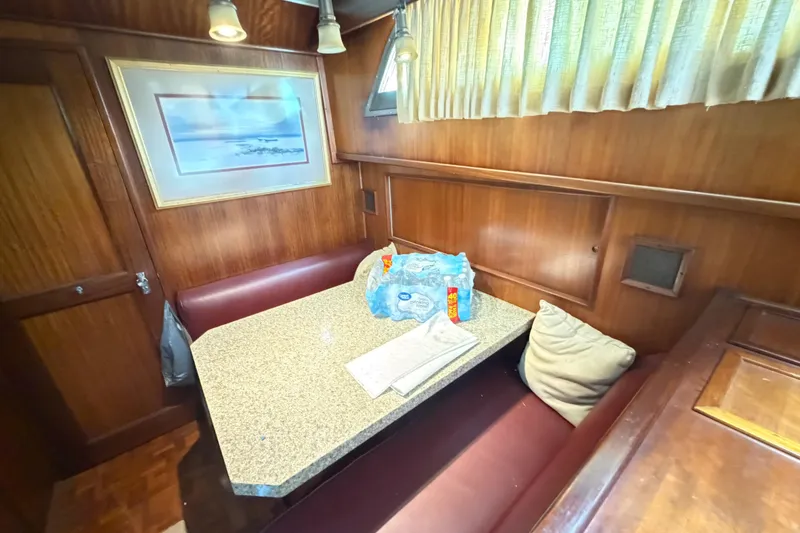 Slide: The Image of 1978 Hatteras 53 Motor Yacht interior with dining area, wood paneling, and framed artwork. - 9