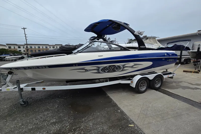 The Image of 2004 Malibu Wakesetter 23 LSV boat on trailer, blue and white design. - 0