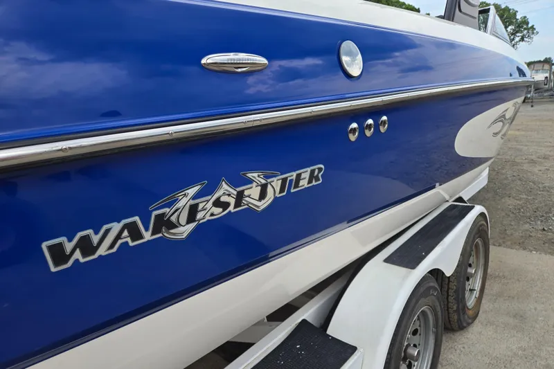Slide: The Image of 2004 Malibu Wakesetter 23 LSV boat with blue and white exterior on trailer. - 15
