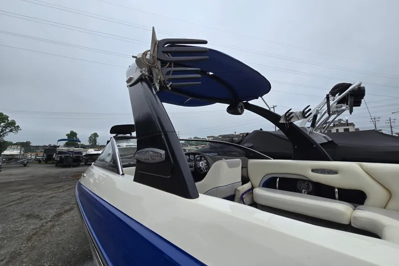 Slide: The Image of 2004 Malibu Wakesetter 23 LSV boat with blue and white interior, docked outdoors. - 20