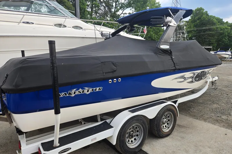 Slide: The Image of 2004 Malibu Wakesetter 23 LSV boat on trailer, covered, parked outdoors. - 22