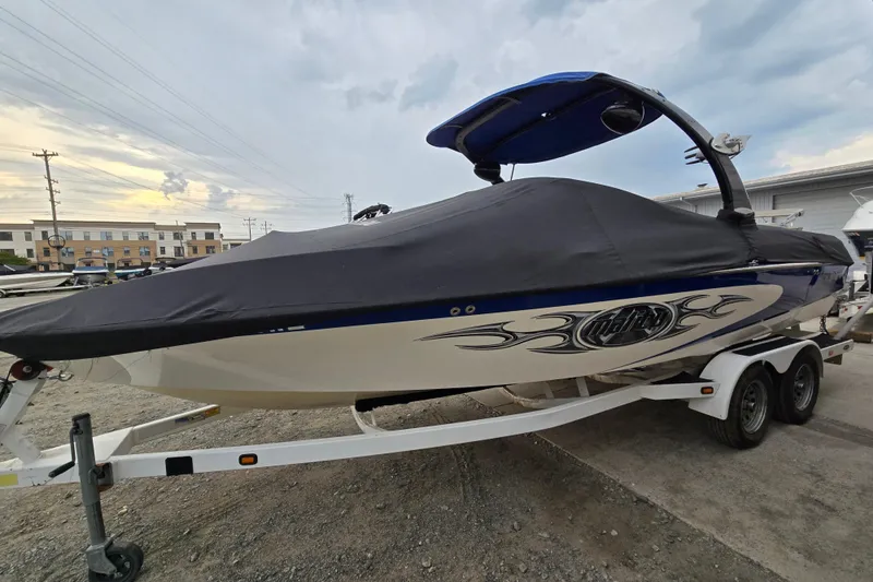 Slide: The Image of 2004 Malibu Wakesetter 23 LSV boat covered on trailer, parked outdoors. - 23