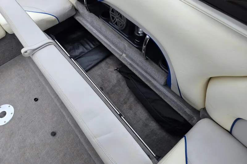 Slide: The Image of 2004 Malibu Wakesetter 23 LSV interior storage compartment with white upholstery and speaker system. - 30