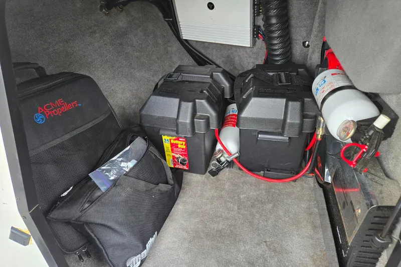 Slide: The Image of Storage compartment of a 2004 Malibu Wakesetter 23 LSV with battery boxes and fire extinguisher. - 50