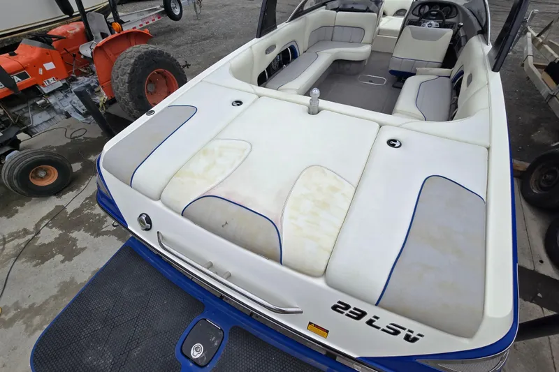 Slide: The Image of 2004 Malibu Wakesetter 23 LSV boat with white and blue interior, docked near equipment. - 58