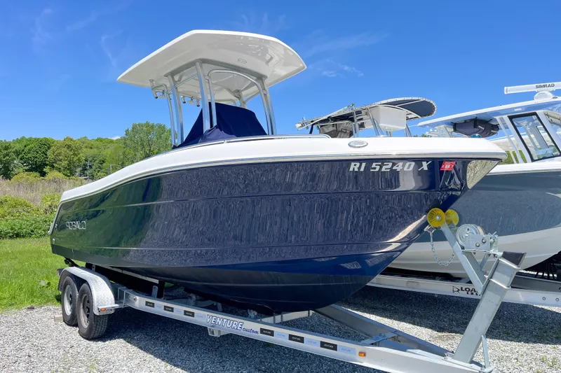 The Image of 2017 Robalo R222 Center Console boat on trailer, parked outdoors under clear blue sky. - 0